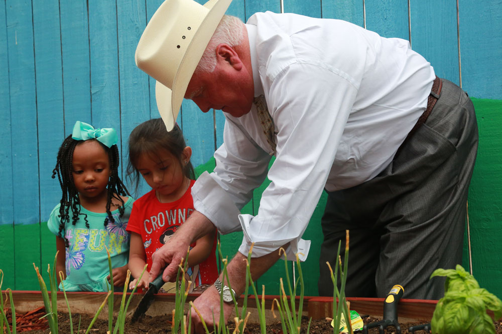 Commissioner Miller assists Kids R Fun students with planting.
